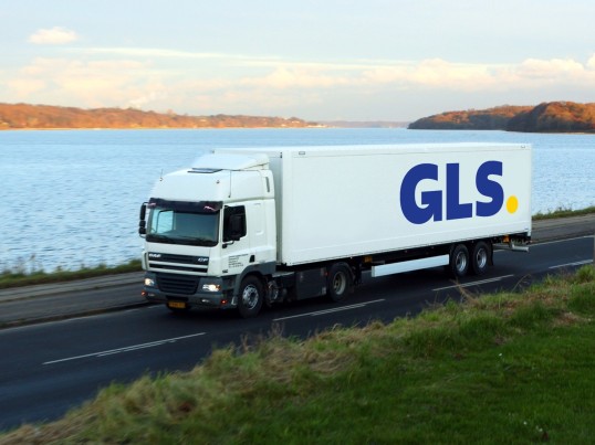 Camionul GLS pe distanțe lungi conduce între câmp și pădure