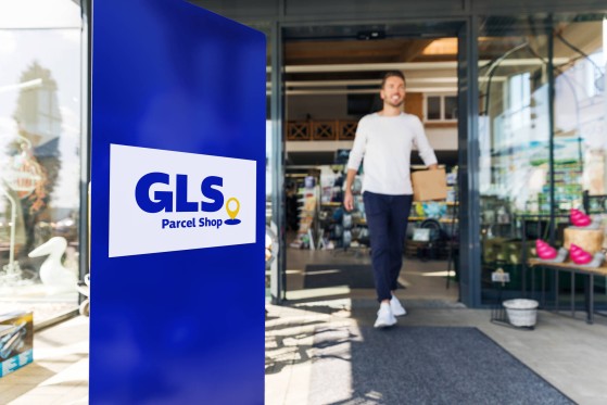 GLS courier with a parcel and handscanner in the street