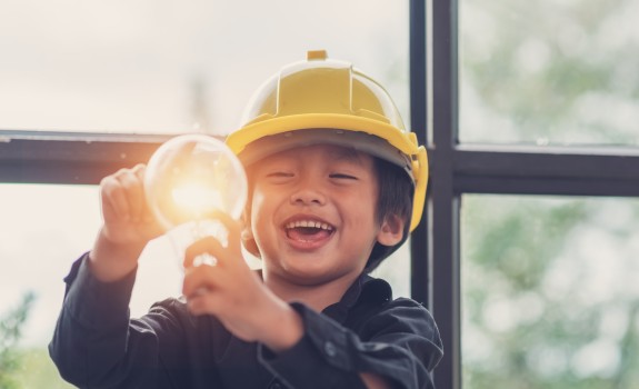 Lachend kind dat een gloeilamp vasthoudt