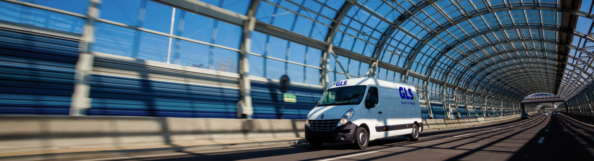 Une camionnette roule dans un tunnel de verre
