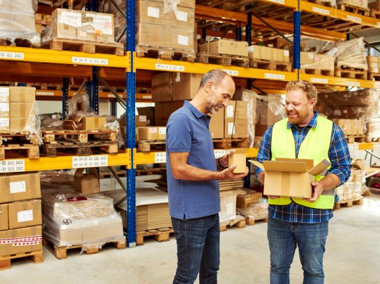 two guys looking at parcels in warehouse