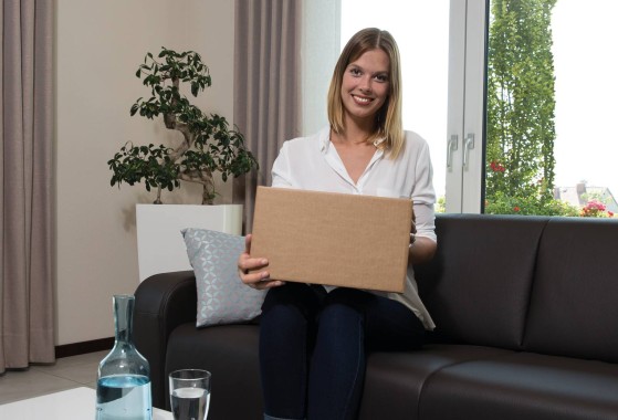woman sitting on a couch with a parcel
