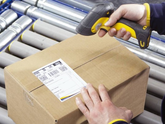 GLS logistics specialist scanning a label on a parcel using a hand scanner