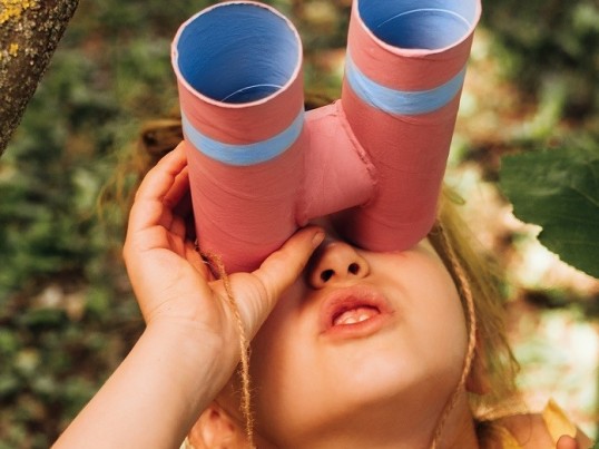Girl with binoculars in a tree