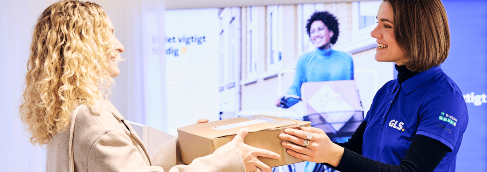 GLS employee delivering a parcel to a female recipient at a ParcelShop.