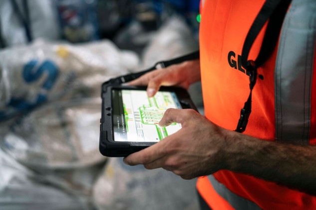 GLS worker using a tablet to sort packages in a logistics warehouse and distribution center