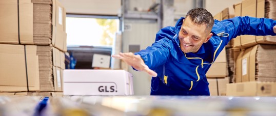 GLS delivery driver hands over parcel to customer on a doorstep