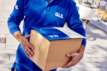 GLS-työntekijä pitää pakettia kädessään