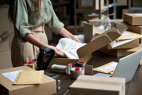 Woman preparing the parcel packaging for shipment to customers.