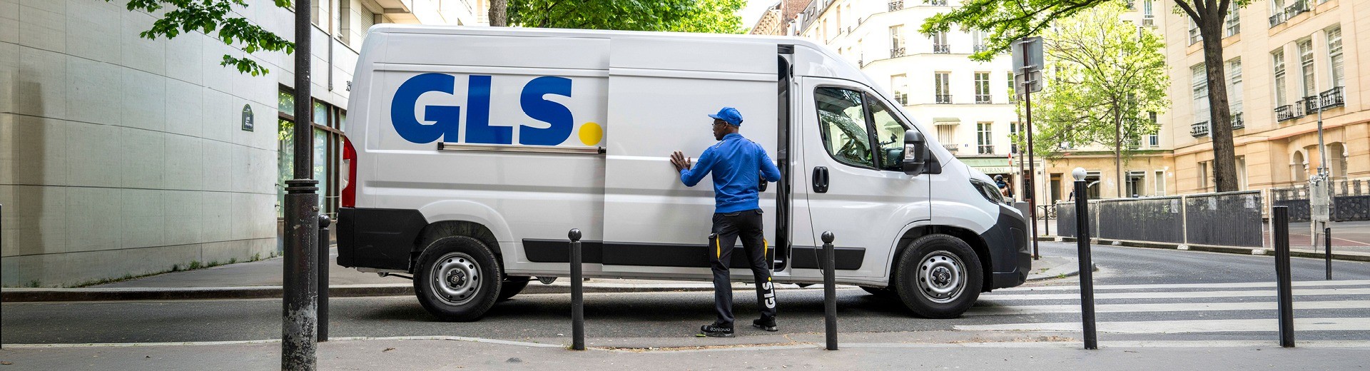 GLS delivery van with courier opening the side door during an urban parcel delivery route.