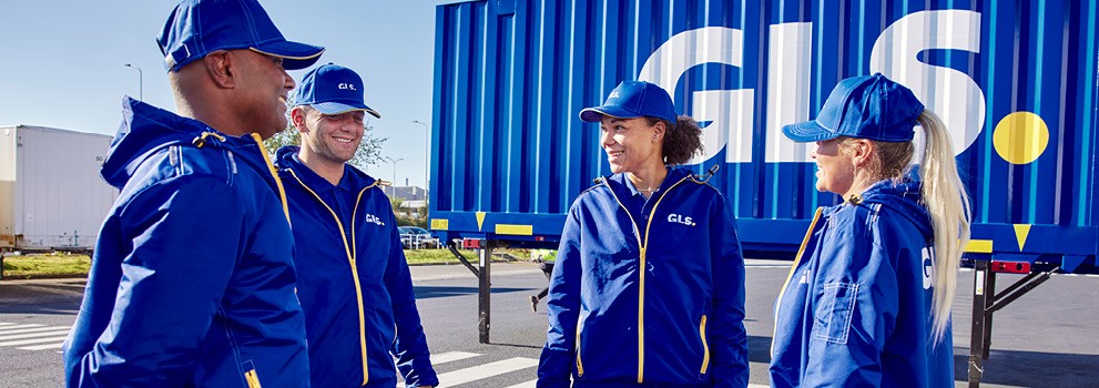 GLS employees in professional uniforms at a logistics site, standing in front of a transport container, illustrating parcel delivery services and last-mile logistics.