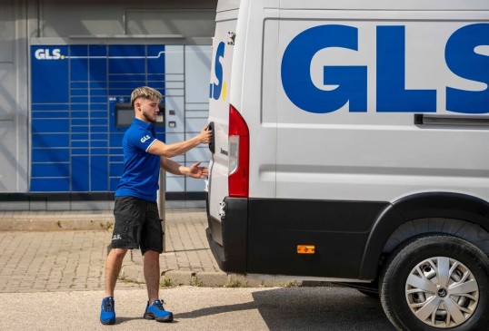 Futár csomagot hoz a GLS Automatába.