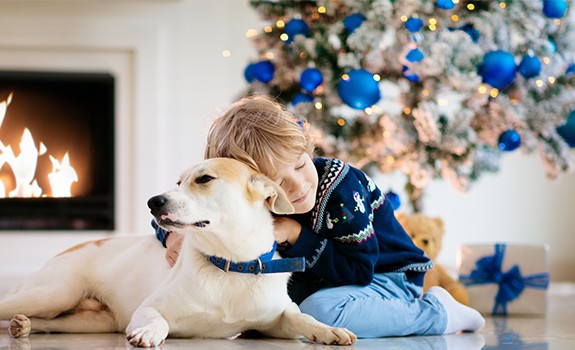 kid and dog in front of the christmas tree