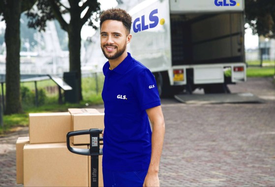 Smiling GLS courier unloading pallet from transport