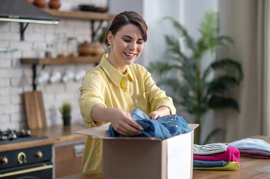 Woman packing parcel in kitchen