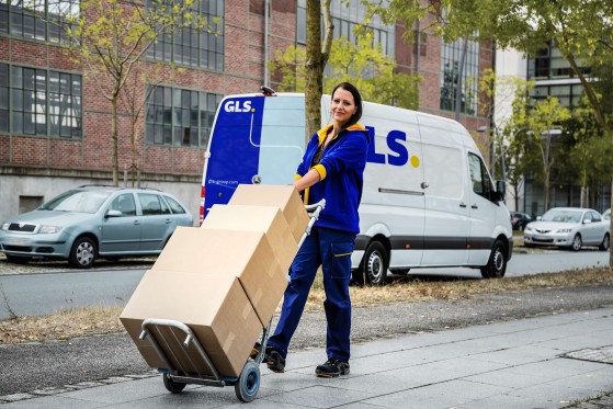 Delivery services and delivery times by female GLS courier with parcels
